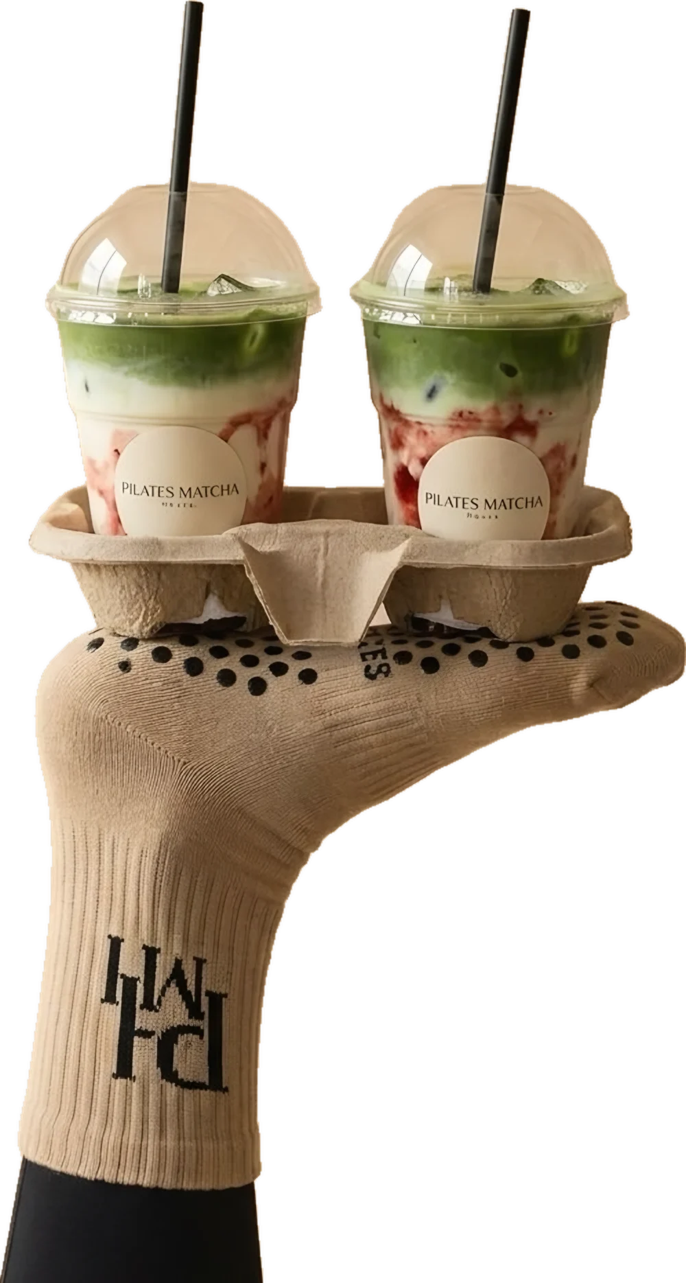 Fuss in PMH Grip Socks balanciert zwei Matcha im Becherhalter